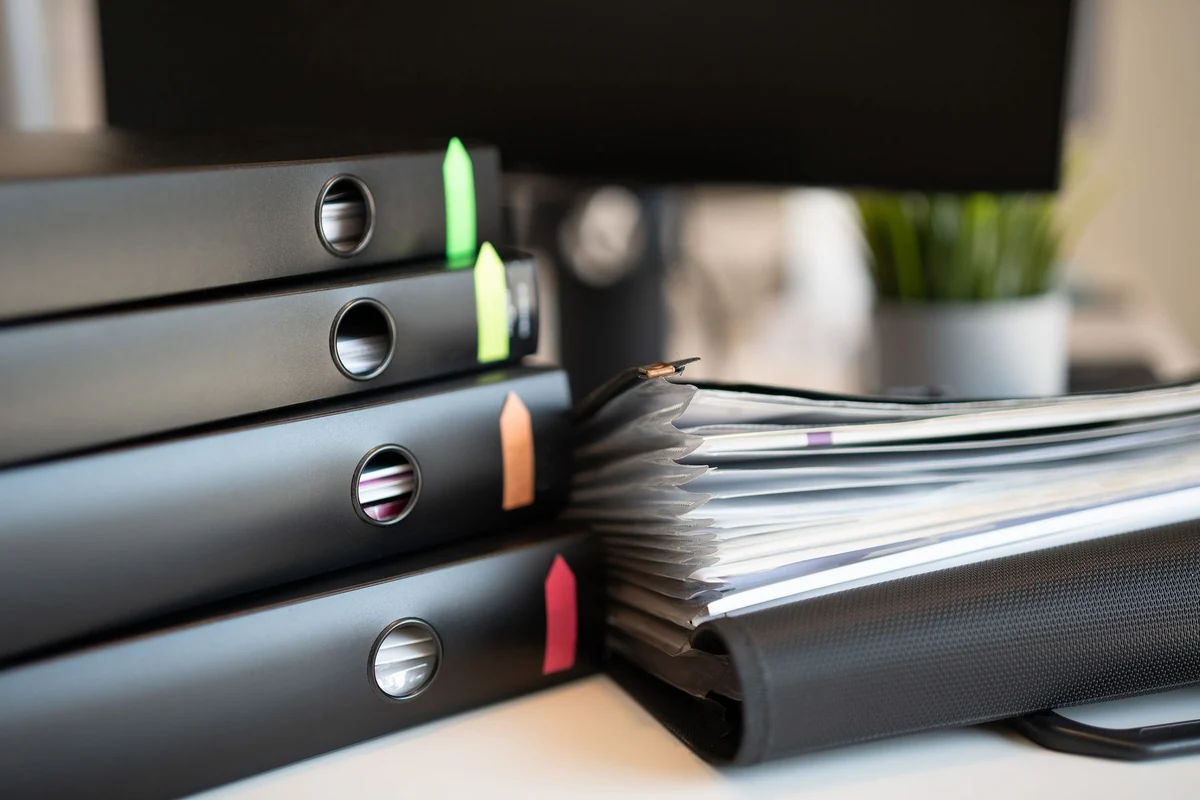 Labelled office binders and paperwork illustrating document categories and retention planning