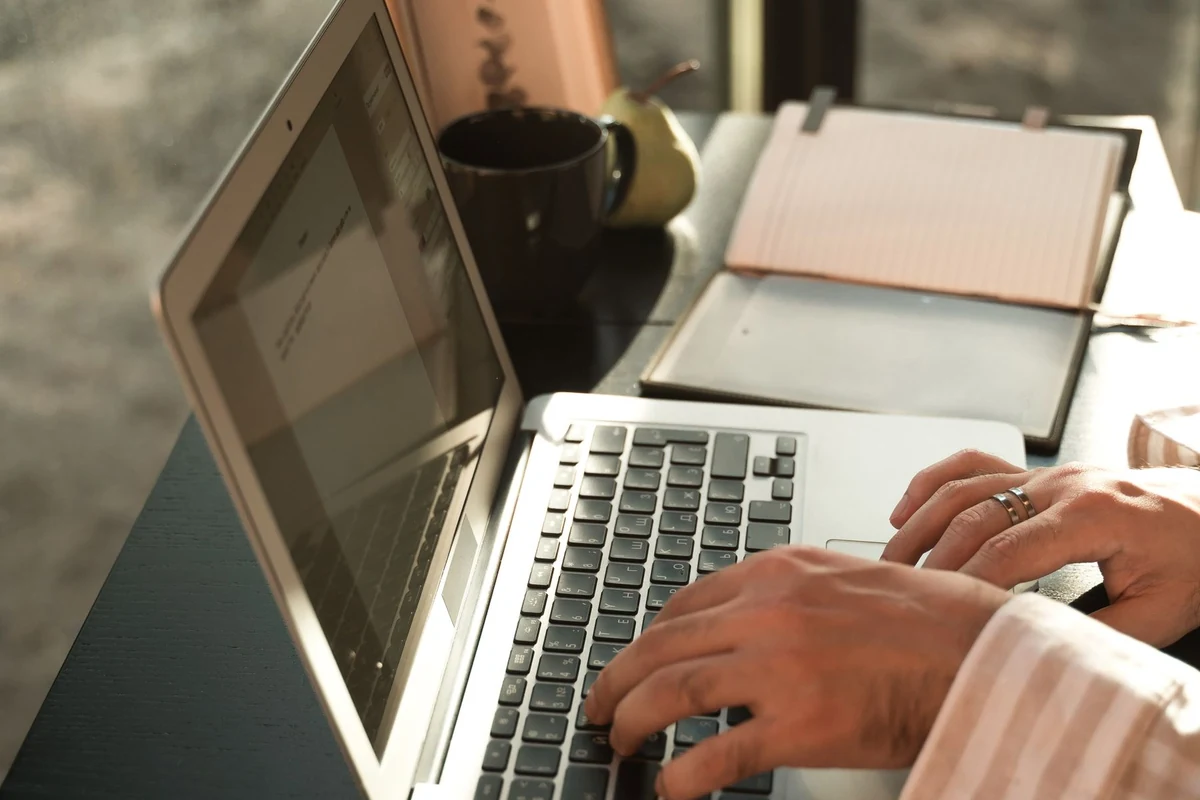 Laptop and paper documents on a desk, illustrating the editable files and records retained at website handover