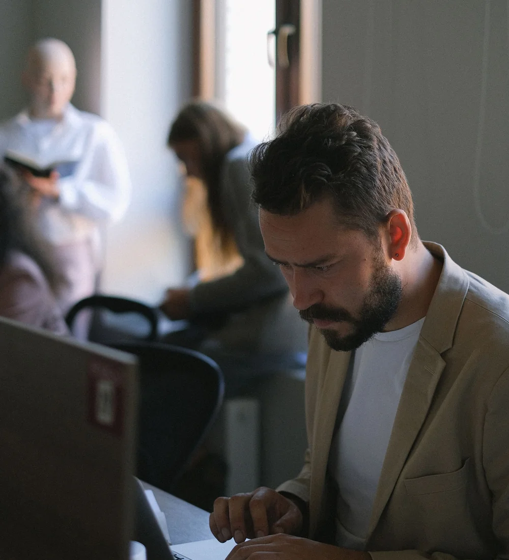 Person reviewing documents beside a laptop, illustrating a website account and handover review